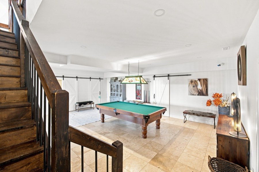 Games room with a full-size pool table, sliding barn doors and a timber staircase