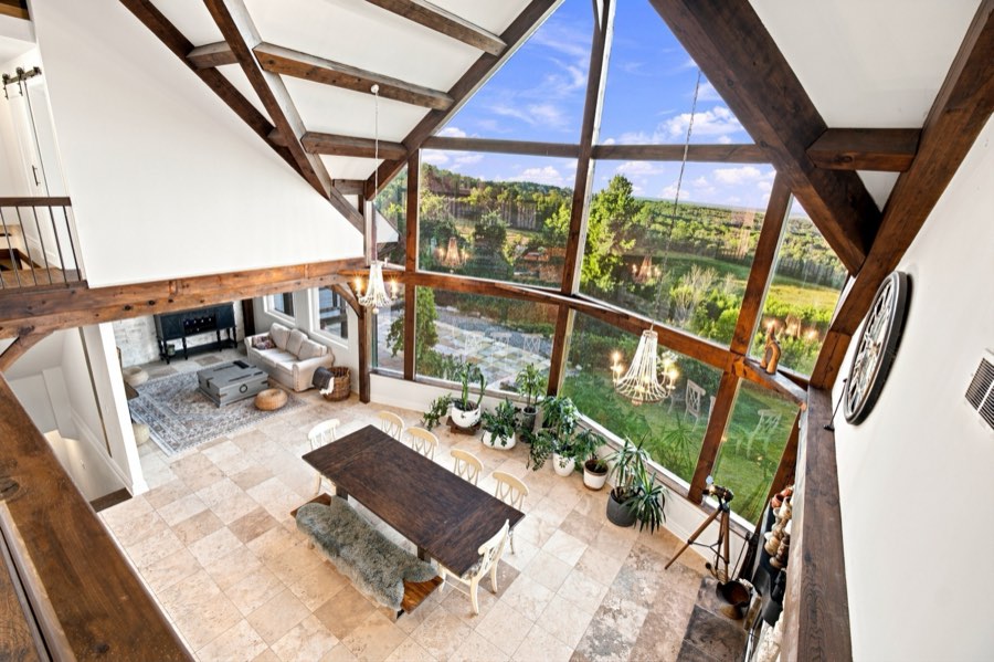 Elevated view from the loft over the dining table, seating area and stone fireplace below