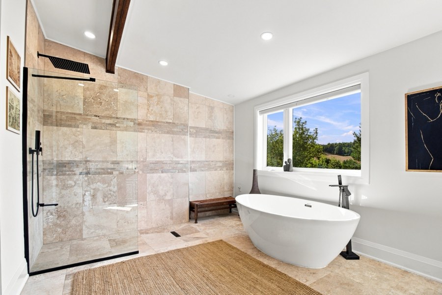 Ensuite with a freestanding tub at the window, a walk-in stone shower and a double vanity