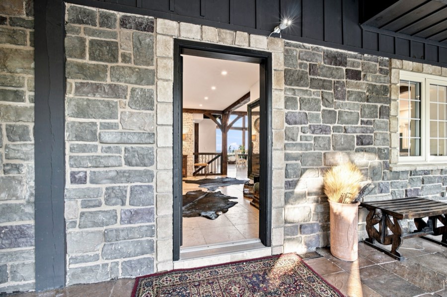 Open front door set into a cut-stone surround, looking through to the timber-framed interior
